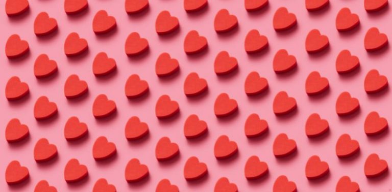 Small, illustrated red hearts in a repeating pattern on a pink background.