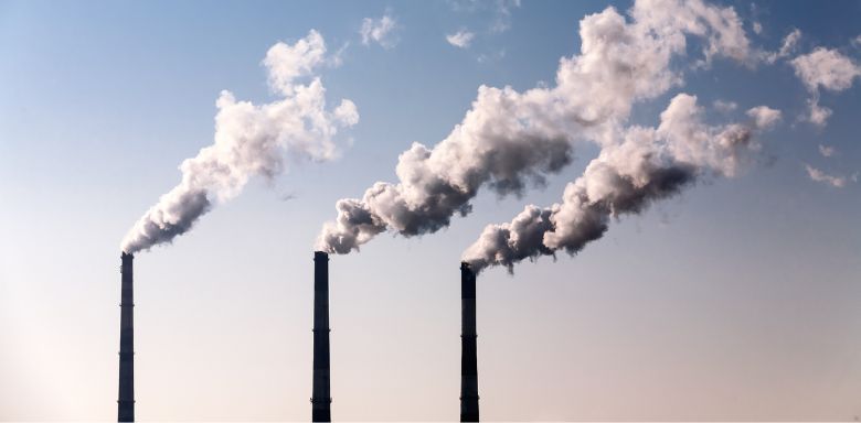 Three smoke stacks emitting air pollution.